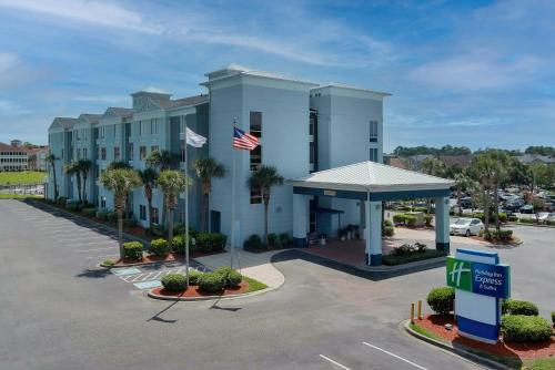 a hotel with a parking lot and an american flag at Holiday Inn Express North Myrtle Beach - Little River by IHG in Little River