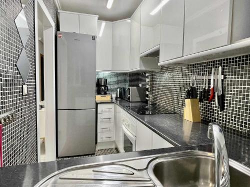 une cuisine avec des armoires blanches et un évier dans l'établissement El mundo soleado, à Santa Pola