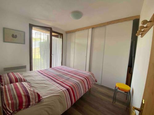 ein Schlafzimmer mit einem Bett und einem gelben Stuhl in der Unterkunft Location appartement in Sainte-Léocadie