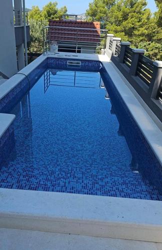 - une piscine avec des carreaux bleus dans un bâtiment dans l'établissement Villa BOTIĆ, à Trogir