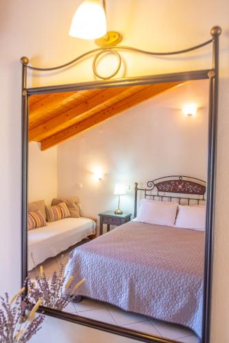 a bedroom with a bed and a mirror at Rousis Studios in Parga