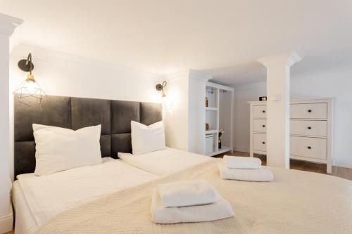 a white bedroom with a large bed with two towels at Golden Apartments Warsaw - Stylish Luxury, Złota Street in Warsaw