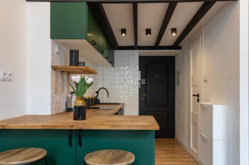 a kitchen with green cabinets and wooden countertops at Golden Apartments Warsaw - Stylish Luxury, Złota Street in Warsaw