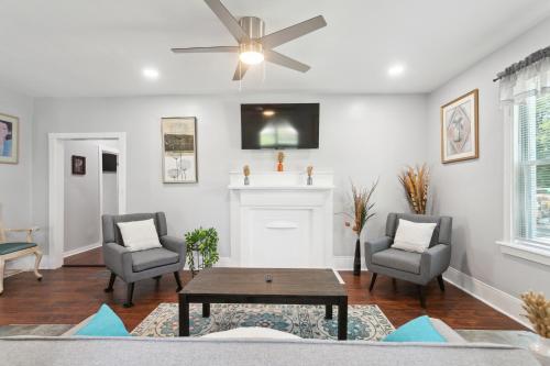 a living room with a ceiling fan and two chairs and a table at ATL Home Close to Airport, Tyler Perry, Betline home in Atlanta