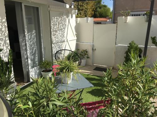 einen Garten mit Topfpflanzen auf einer Terrasse in der Unterkunft petite maison cosy avec exterieur in Marseille