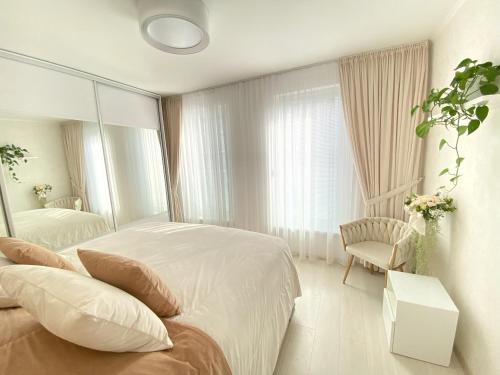 um quarto branco com uma cama e um espelho em Die Eleganz - Exclusive Apartment near the City Center em Bratislava