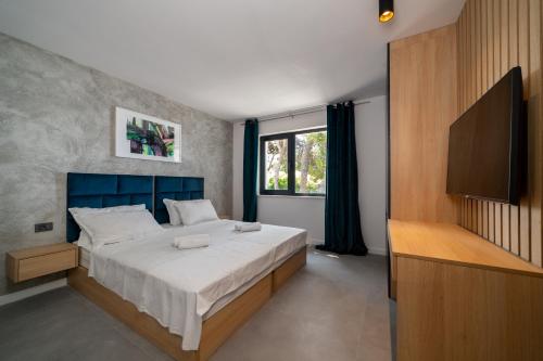 ein Schlafzimmer mit einem großen Bett und einem TV in der Unterkunft Villa Orizzonte in Sumartin