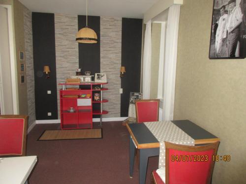 une salle à manger avec une table et des armoires rouges dans l'établissement chambre chez l'habitant, à La Goulandre