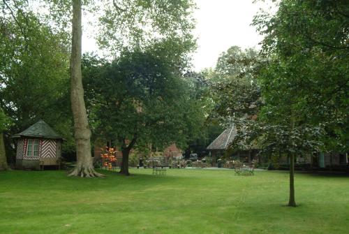 a park with a gazebo and a tree at Charmehotel Manoir Ogygia in Poperinge