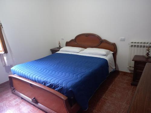 a bedroom with a bed with a blue comforter at Agriturismo Fonte Magria in Abbadia San Salvatore