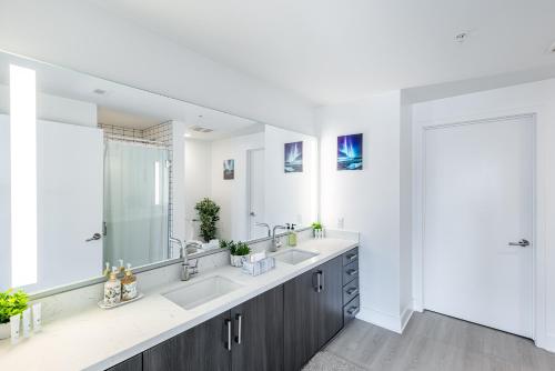 uma casa de banho com 2 lavatórios e um espelho grande em Top Floor 3 Bed 3 Bath Penthouse Living In Luxury em Los Angeles