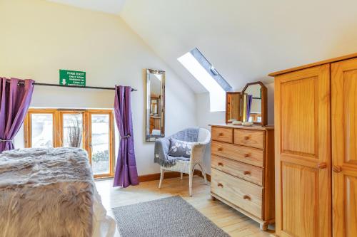 a bedroom with a bed and a dresser and a mirror at Miller's Lodge in Liskeard