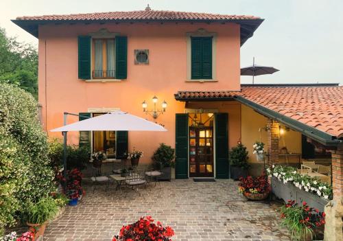 a house with an umbrella and a patio at La Valletta Relais in Bergamo