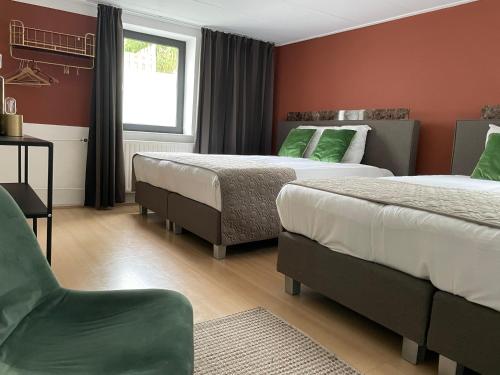 a hotel room with two beds and a chair at Valkenhof in Valkenburg