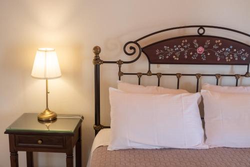 a bedroom with a bed and a table with a lamp at Rousis Studios in Parga