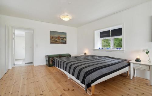 a white bedroom with a bed and two windows at 1 Bedroom Amazing Apartment In Rønne in Rønne