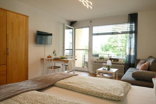 1 dormitorio con cama, sofá y ventana en Ferienwohnung am Holdereggenpark, en Lindau