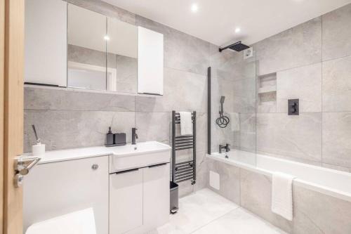 y baño con lavabo, bañera y ducha. en Stylish Central Reading Apartment - Free Parking en Reading