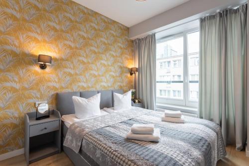 - une chambre avec un lit et une grande fenêtre dans l'établissement Golden Apartments Warsaw - Luxury Building with Terrace on the Roof - Sienna Str, à Varsovie