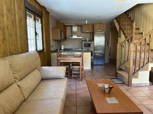 uma sala de estar com um sofá e uma cozinha em Casa Miravalles Fornela 