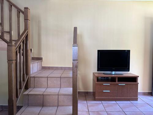 una sala de estar con TV en un vestidor y escaleras en Casa Miravalles Fornela, 