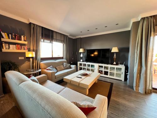 een woonkamer met een bank en een tafel bij PUSHE Penthouse Playa Granada Beach & Golf 2 in Motril