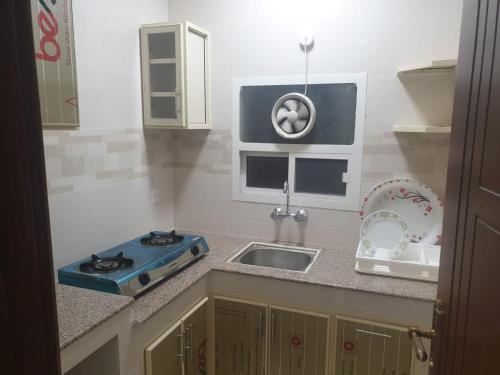 una piccola cucina con lavello e fornello di Rose Apartment a Salalah