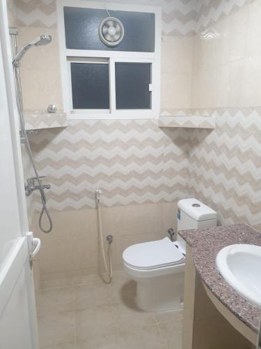 un bagno con WC, lavandino e doccia di Rose Apartment a Salalah