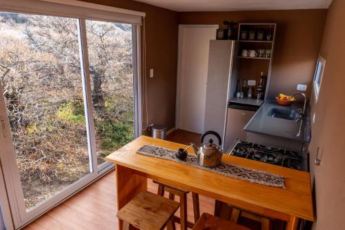 uma cozinha com um balcão com um fogão e uma janela em Aizeder - Eco Container em El Chaltén