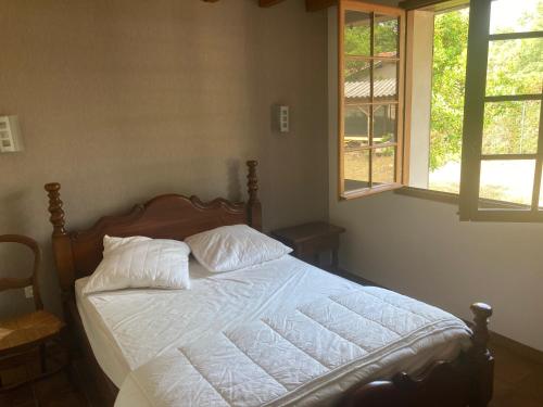 un lit avec des draps blancs et des oreillers dans une chambre dans l'établissement maison moliets, à Moliets-et-Maa