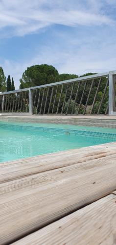 una valla sobre una piscina de agua en un paseo marítimo en Aux berges du pont du gard, en Vers Pont du Gard