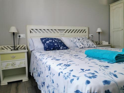 een slaapkamer met een bed met een blauw en wit dekbed bij San Pedro in Cangas de Foz