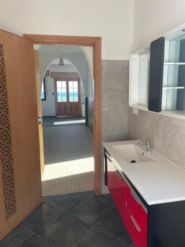 eine Küche mit einer Tür, die auf einen Flur führt in der Unterkunft Appartement Dikki Plage in Melîyech