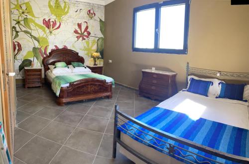 um quarto com 2 camas individuais e uma janela em Appartement Dikki Plage em Melîyech