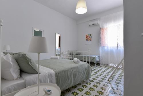 a white bedroom with a bed and a table at Le Sorelle Villa sul mare in Porto Empedocle