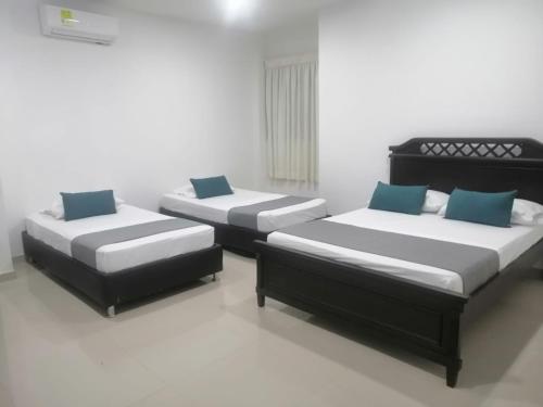 two beds sitting in a room with at Aveiro Hotel in Cúcuta