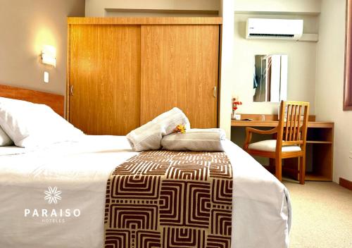a bedroom with a bed and a desk and a chair at Hoteles Paraiso TRUJILLO in Trujillo