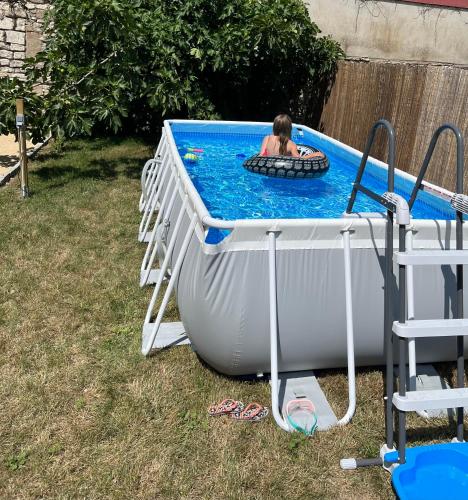 une personne dans un pool avec une personne dans un bain gonflable dans l'établissement Côte-et-vins Gite du Prieuré, à Chagny