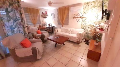 a living room with couches and a table at Chalet de 2 chambres avec jardin clos et wifi a Saint Joseph in Saint-Joseph