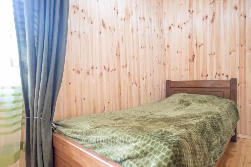 a bedroom with a bed and a wooden wall at Babi & Tata's House in Ushguli