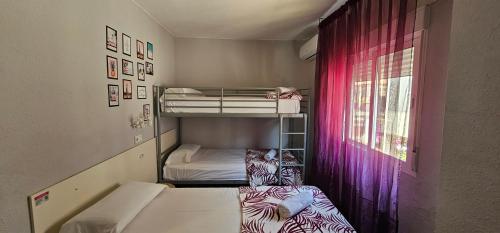 Habitación pequeña con 2 literas y ventana en Hostal La Cabaña en Salou