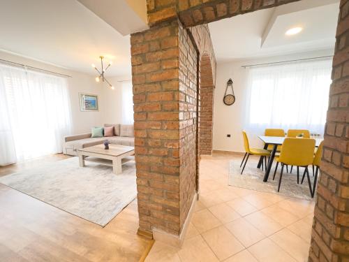 una sala de estar con una pared de ladrillo y una mesa en Luxurious and Cosy Brick Apartment - Free private parking, en Sarajevo