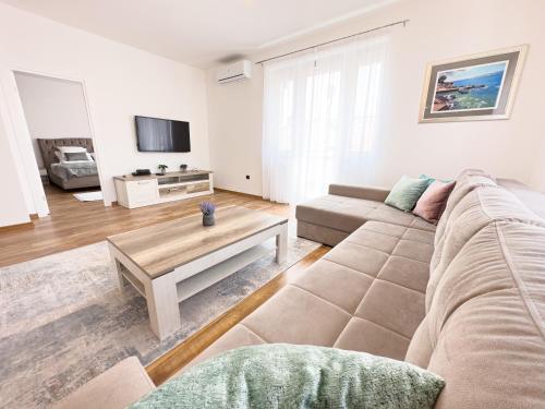 uma sala de estar com um sofá e uma mesa em Luxurious and Cosy Brick Apartment - Free private parking em Saraievo
