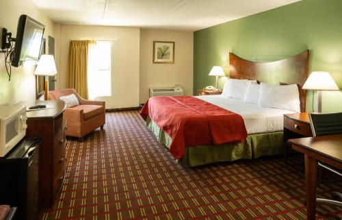 Habitación de hotel con cama y silla en Select Inn Murfreesboro, en Murfreesboro