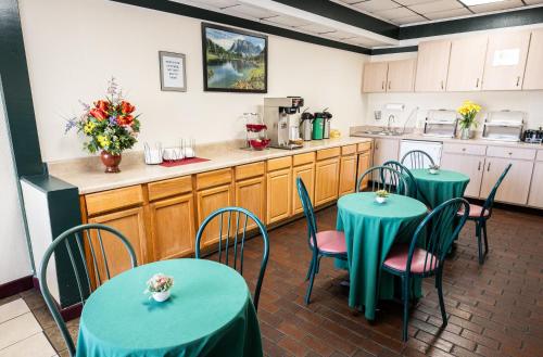 a dining room with two tables and a kitchen at Select Inn Murfreesboro in Murfreesboro