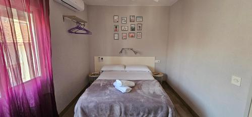 a small room with a bed with a purple curtain at Hostal La Cabaña in Salou