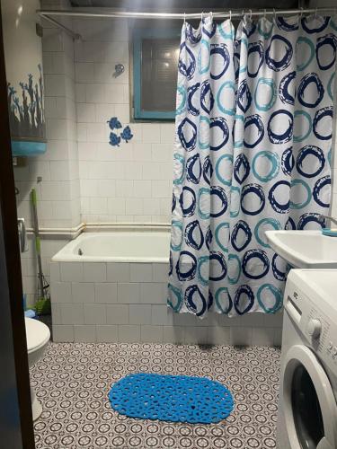 een badkamer met een douche en een blauw-wit douchegordijn bij Central City Touch in Skopje