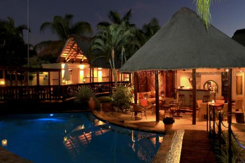 un complejo con piscina por la noche en La Lechere Guest House en Phalaborwa