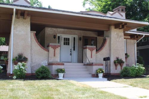 a small house with a white door and stairs at Spanish Charm 4bed/3bath in Waupaca