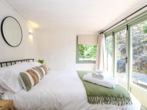 a white bedroom with a bed and a window at Vintner's Cottage in Norwich